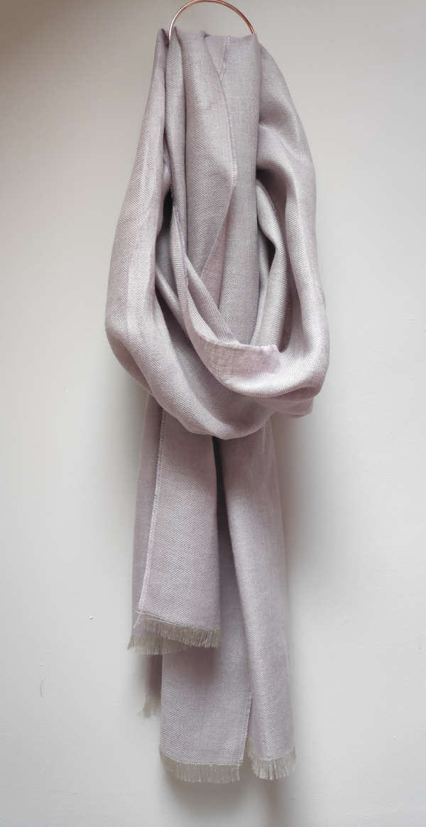 100% Irish Linen Scarf in a dusky lavender colour draped from a circle hook on a white wall.